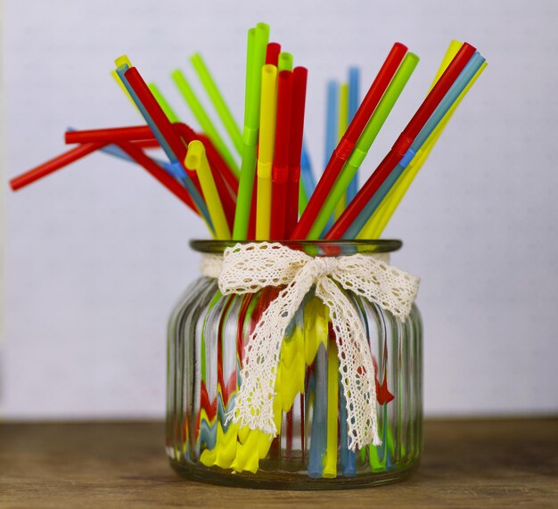 Colored plastic cocktail tubes standing in a glass side view