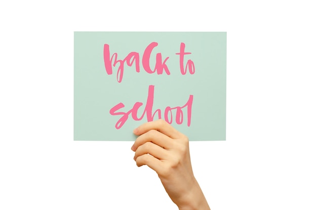 A colored poster in the girl's hand Handwritten inscription Back to school Isolated on white