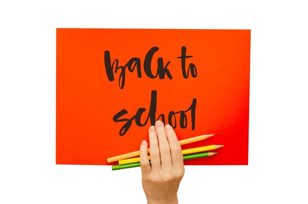 Photo a colored poster in the girl's hand handwritten inscription back to school isolated on white