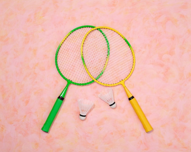 Colored rackets for playing badminton and shuttlecocks Top view of sport play
