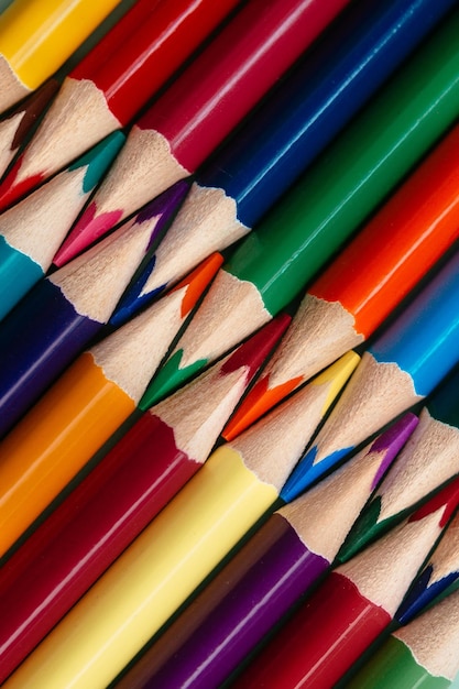 Colored sharpened pencils lie in a row closeup solid abstract background of wooden multicolored pencils
