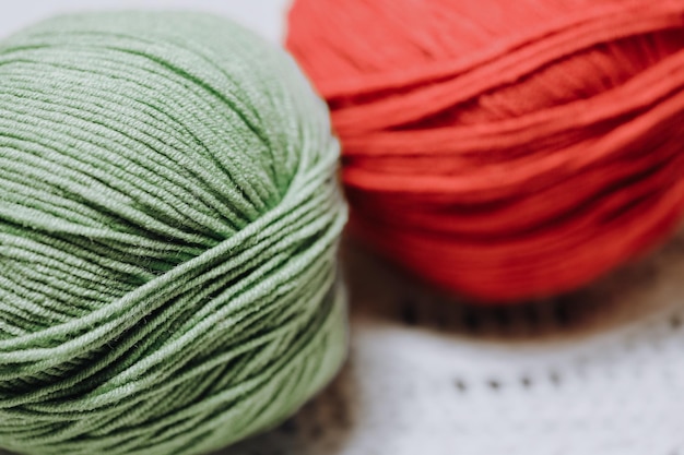 Colored skeins of wool lie on a white knitted napkin. High quality photo