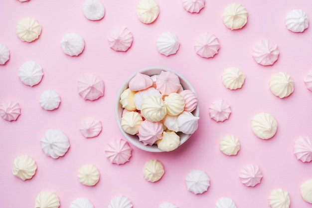 Colored small meringues on pink. Flat lay concept. Copy space.