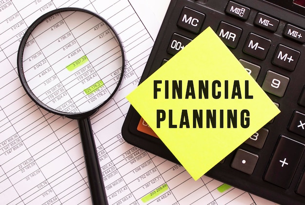 Photo a colored sticker with the text financial planning lies on the calculator financial concept