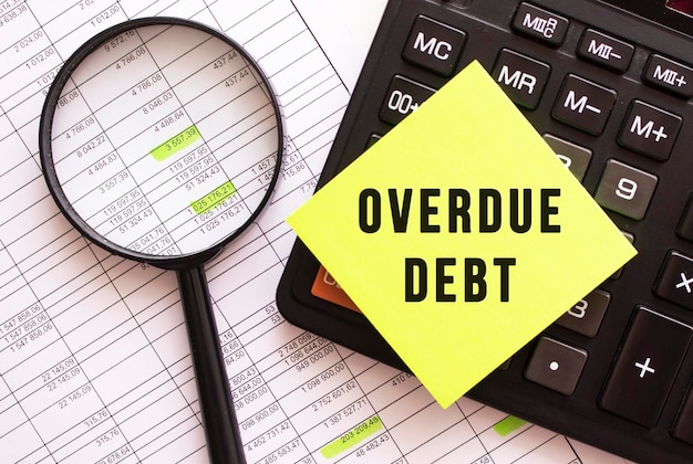 テキスト OVERDUE DEBT の付いた色付きのステッカーが電卓にあります 金融の概念