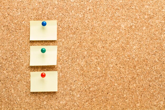 Colored sticky notes hanging on a cork board