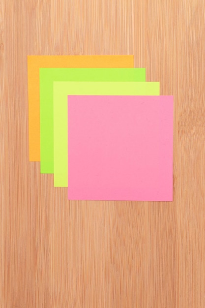 Photo colored sticky notes pinned to the wooden message board