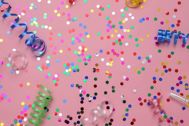 Photo colored streamer and confetti on a pink background holiday birthday background