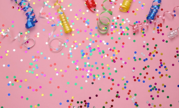 Colored streamer and confetti on a pink background Holiday birthday background