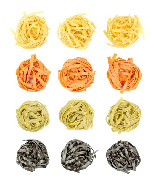 Photo colored tagliatelle nests on white background