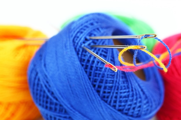 Colored threads with needles for embroidery, on a white background