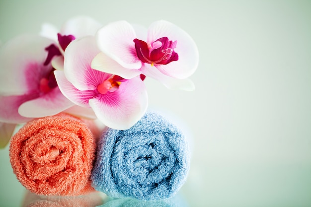 Colored towels and orchid on white table with copy space on bath room 