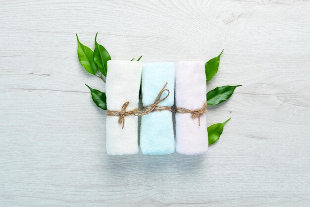 Colored towels for spa treatments On a white wooden background Flat lay