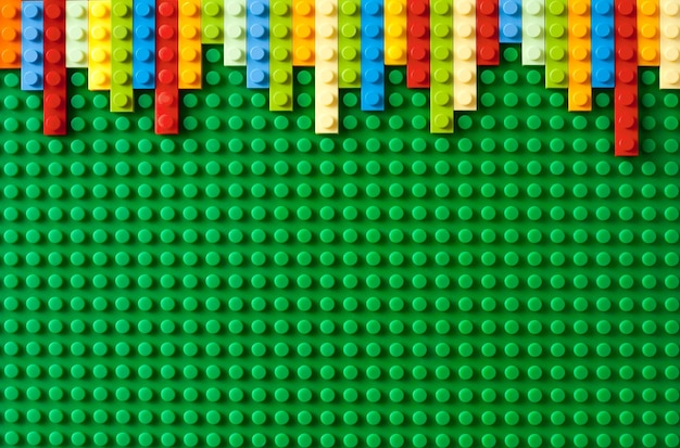 Photo colored toy bricks on green background