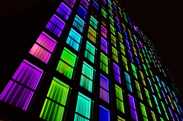 Colored windows texture.  Windows illuminated by neon lights background.