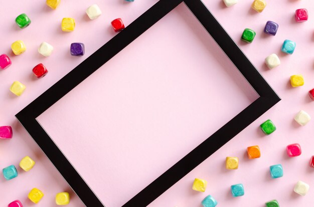 Colored wooden beds composition frame on pink background.