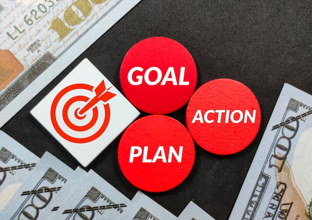 Colored wooden board banknotes with the words goal plan and action