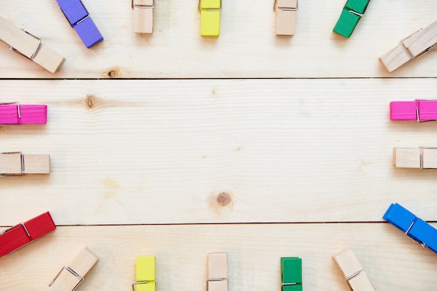 colored wooden clothespins on wooden background