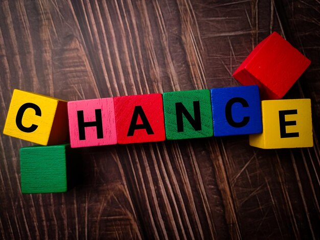 Colored wooden cube with word CHANCE on a wooden table background