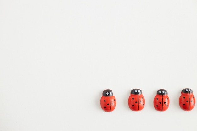 Colored wooden figures in the form of ladybugs on a white background