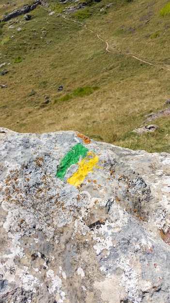 노란색 녹색 선으로 표시된 산책로 표지판 및 등산로 산 간판 벽 돌의 통로
