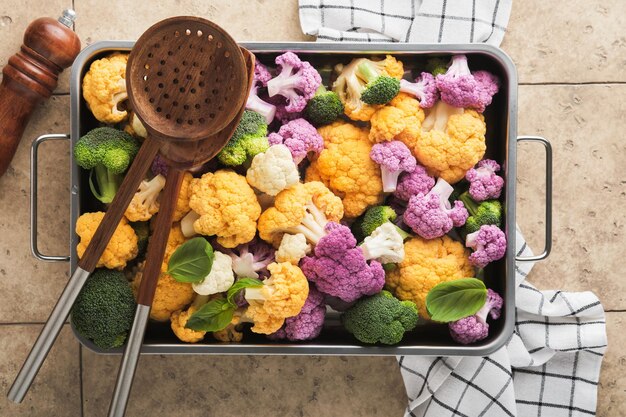 Colorfu cauliflower Cauliflower cut into small pieces in iron pan on old gray stone tile background Food cooking and agricultural harvest concept or background