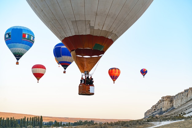 Colorful air balloons flying in clear sky near huge white mountain