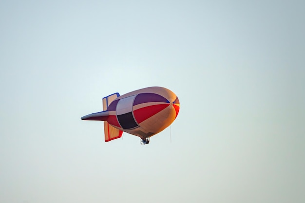 a colorful airship flies in the blue sky