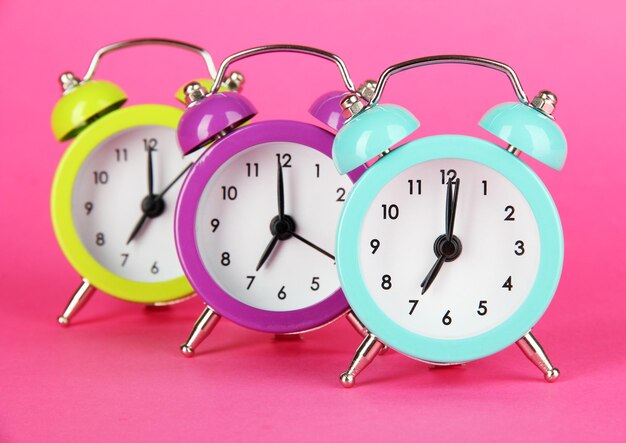 Photo colorful alarm clock on pink background