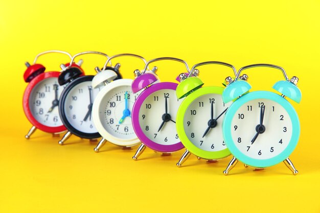 Colorful alarm clock on yellow background