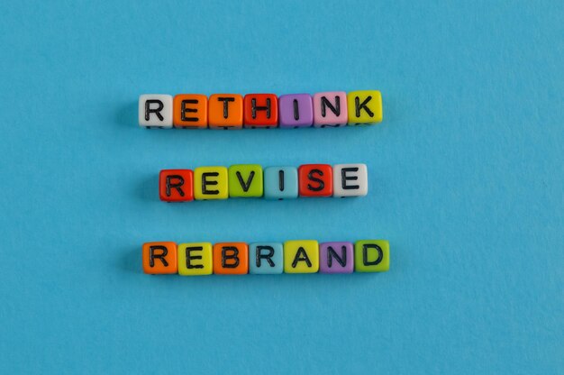 テキスト RETHINK REVISE と REBRAND のカラフルなアルファベット ビーズ