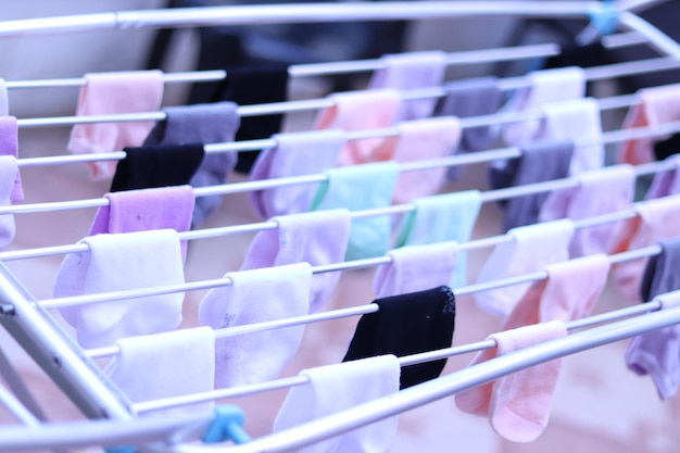 Colorful ankle socks hang on a clothesline in a straight line