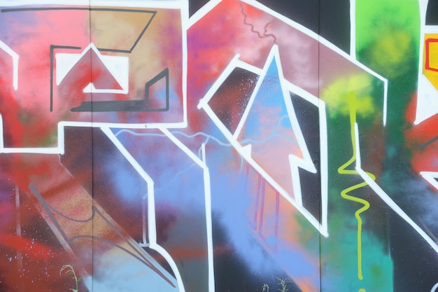 Colorful background of graffiti painting artwork with bright aerosol strips on metal wall