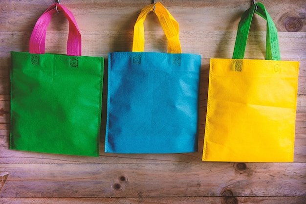 Photo colorful bags hanging on wooden wall