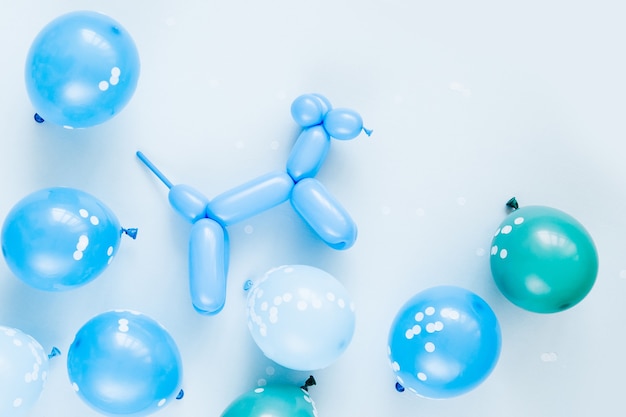 Colorful balloons and balloon dogs on pastel blue background. Festive or birthday party concept. Flat lay, top view.