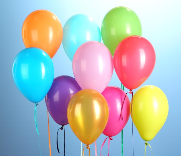 Colorful balloons on blue background closeup