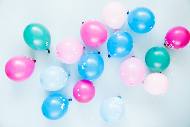 Colorful balloons on pastel blue  background. Festive or birthday party concept. Flat lay, top view.