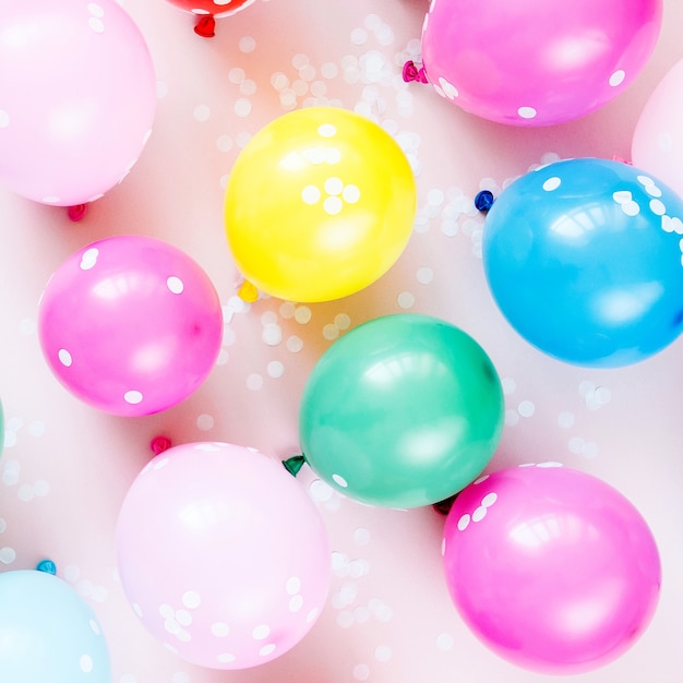 Colorful balloons on pastel color background. Festive or birthday party concept. Flat lay, top view.