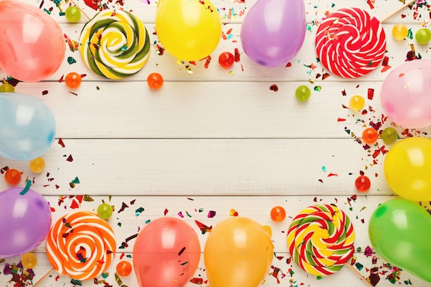 Colorful balloons on white rustic wood birthday background top view