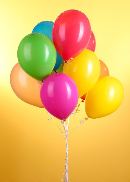 Colorful balloons on yellow background