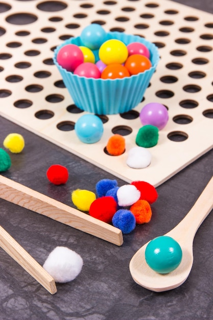 Colorful balls as accessories using for playing and development of kids motor skills coordination and logical thinking