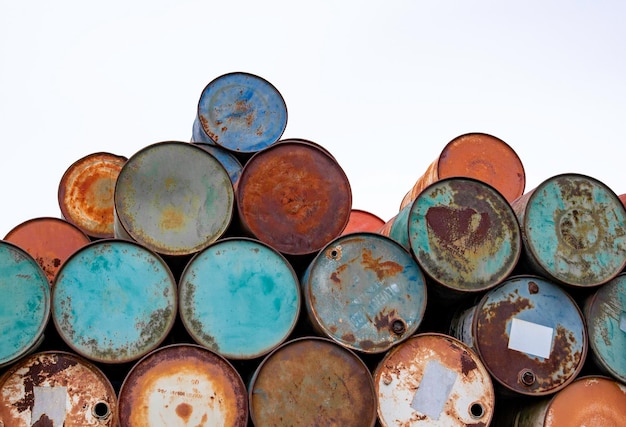 Colorful barrels for storing oil metal canisters casks for fuel\
stacked in row isolated on white background