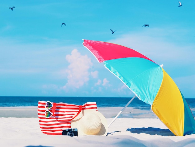 夏の間空を背景に砂の上に色とりどりのビーチ傘