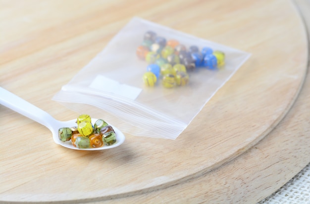 Colorful beads on a wooden surface. 