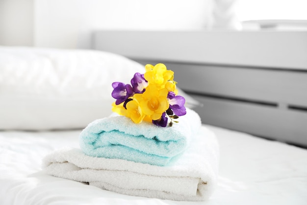 Colorful beautiful freesias on fresh towels in hotel close up