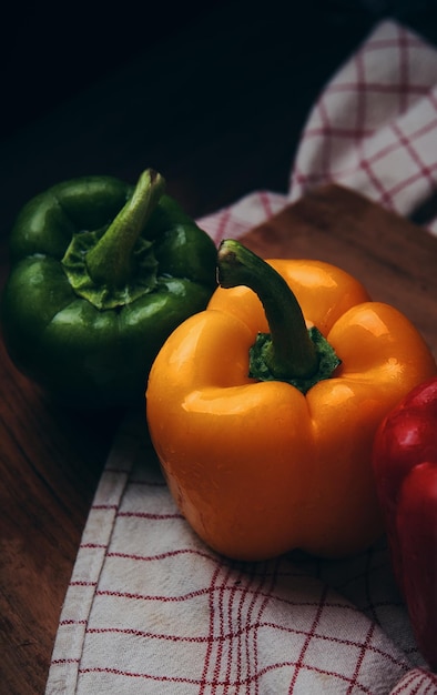 A colorful bell pepper sits on a wooden cutting board.