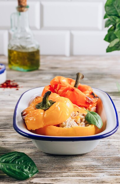 Colorful bell stuffed paprika peppers with meat rice and vegetables on white wooden background Selective focus