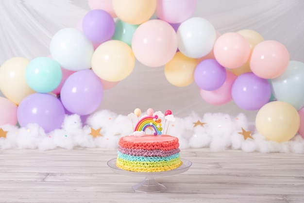 Foto torta di compleanno colorata. torta arcobaleno con palloncini colorati pastello. festa di compleanno.