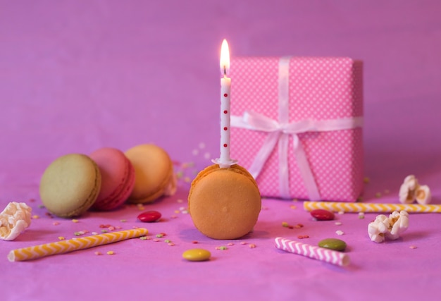 Colorful birthday macaroon cake with burning candle