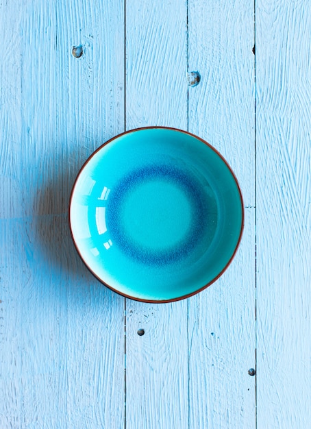 Photo colorful blue dish over a light blue painted wood table